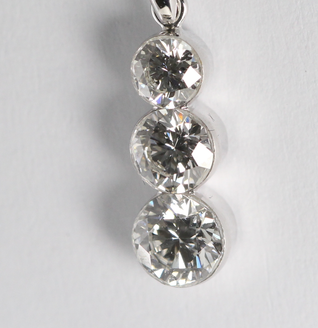 This 18 karat white gold diamond trilogy pendant shows off its diamonds expertly via its setting